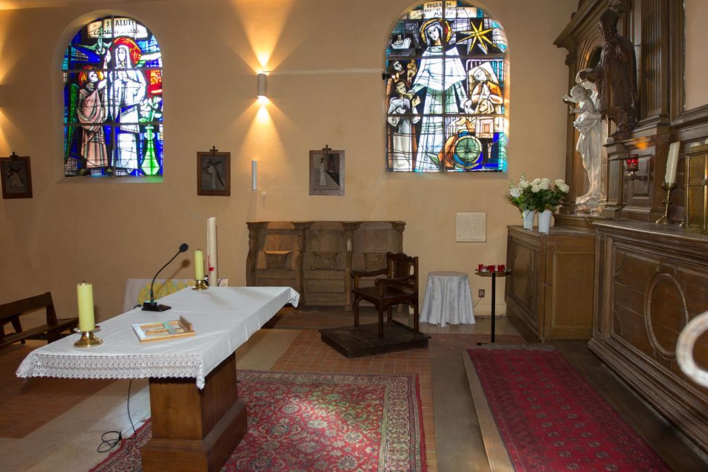 Vue de l'intérieur de l'Église Saint-Marcel de Villabé. Vue du chœur : le retable, deux vitraux, l'autel et les stalles du côté gauche de l'église.
